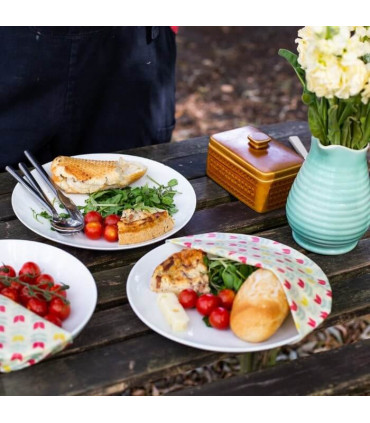 Table ornée d’assiettes avec leurs légumes frais protégés par des feuilles enduites de cire d’abeilles