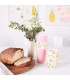 Three stacked Love Mae floral pattern and pink colored bamboo tumblers with bread on the side 